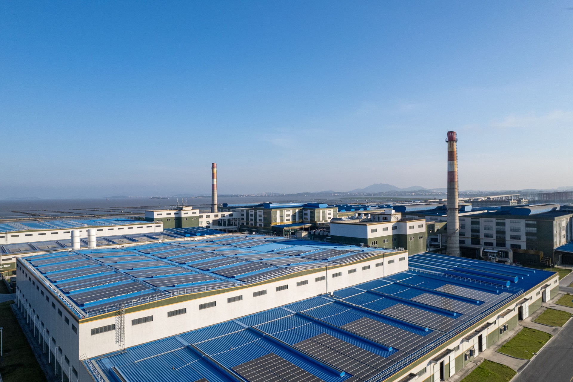 Aerial view of a factory installing solar panels on the roof