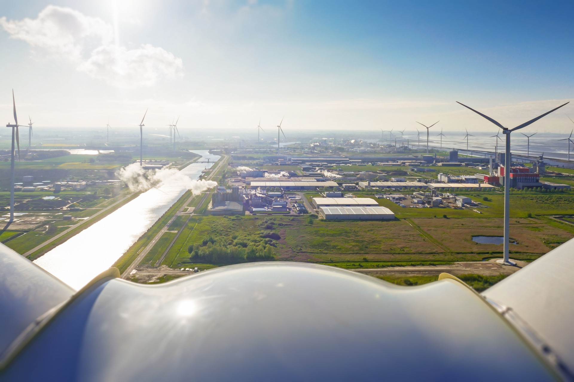 Vue épique depuis une éolienne aux Pays-Bas sur un parc éolien autour du canal et de la zone industrielle. Ensoleillé.